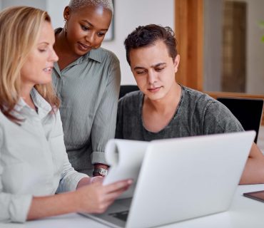 Shot of a group of businesspeople working together on a laptop in an office.